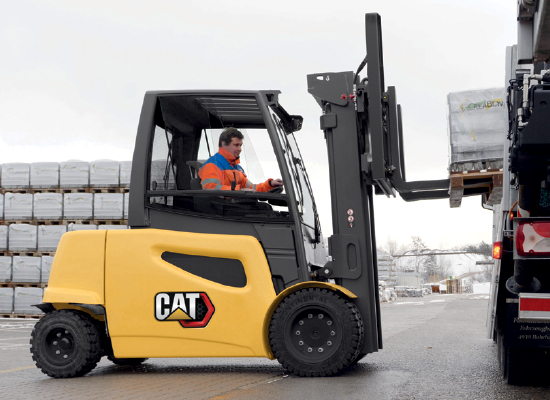 Worker moving blue barrels on pallet with Cat class i forklift